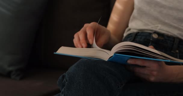Девушка держит бумажную книгу и переворачивает простыни. Молодая женщина читает книгу. Медленное движение. - Кадры, видео