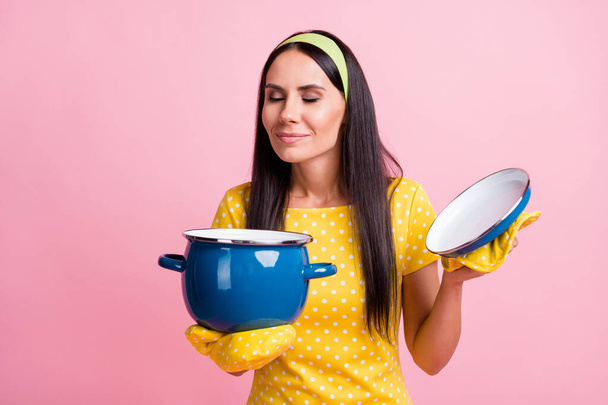 Photo of attractive brown haired woman wear yellow dotted t-shirt hold pan smell soup isolated on pink color background - Φωτογραφία, εικόνα