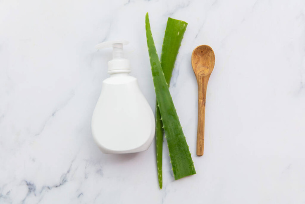 Aloe vera natural skincare white product bottle with green leaves. Flat lay composition - Foto, Imagen
