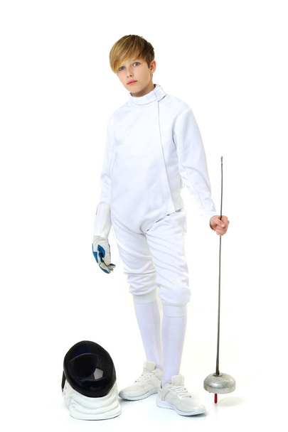 Boy in fencing costume posing with sabre and mask - Photo, image