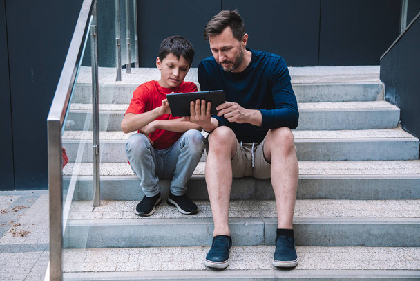 Vater und Sohn haben viel Spaß beim gemeinsamen Spielen am Tablet. Moderne Technologien. Lebensstil. Hochwertiges Foto - Foto, Bild