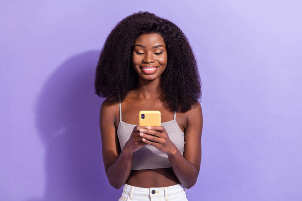 Портрет привлекательной сфокусированной веселой девушки с помощью устройства гаджет smm обратной связи изолированы на фиолетовый фиолетовый цвет фона - Фото, изображение
