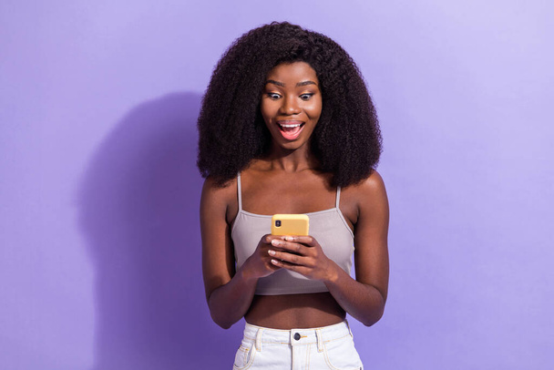 Retrato de menina alegre surpreendente atraente usando dispositivo de navegação feedback de mídia isolado sobre violeta cor roxa fundo - Foto, Imagem