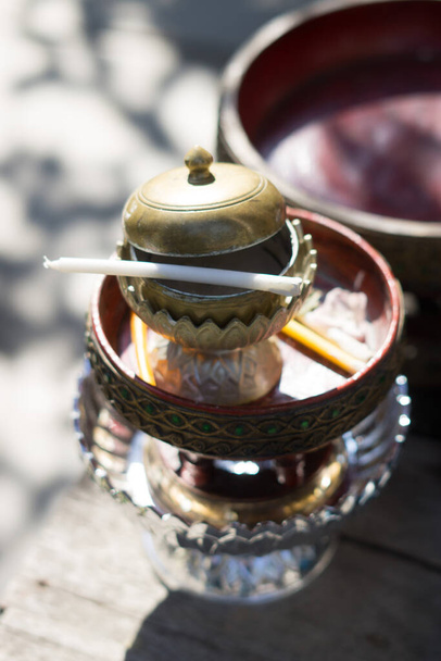 Copa de cerámica y el hilo santo con agua bendita es un budista en bandeja de oro y tazón de oro para la ceremonia de compromiso tailandesa. - Foto, Imagen