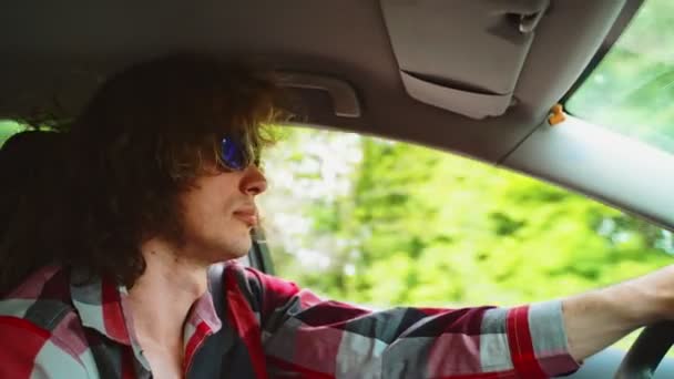 Egy férfi kék napszemüvegben autót vezet.. - Felvétel, videó