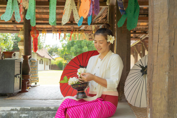 Portré mosolygós ázsiai Shan nő lány, Tai Yai, észak-thai emberek hagyományos Lanna ruhák kezében virágok Wat Ton Kwen templom, lámpások dekoráció. Kultúra életmód. - Fotó, kép