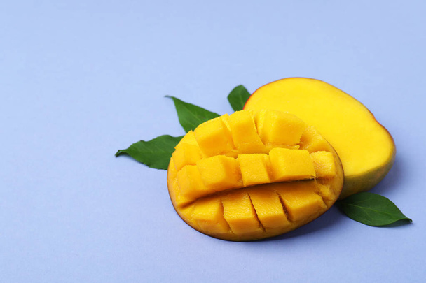 Tasty ripe mango fruit on violet background - Photo, Image