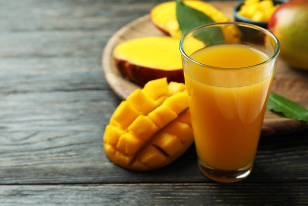 Ripe mango fruit and juice on wooden table - Φωτογραφία, εικόνα