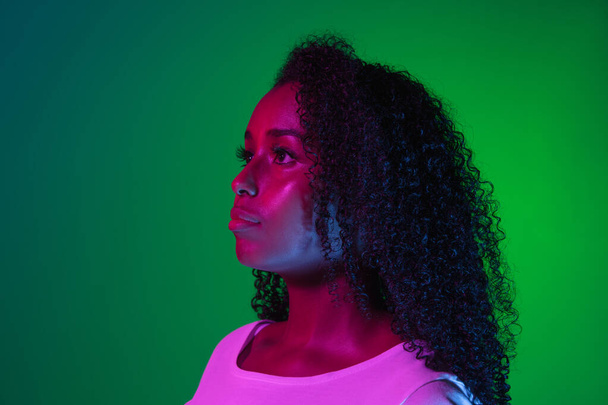 Serious. Latino womans portrait isolated on studio background in neon. Beautiful female model. - Fotó, kép