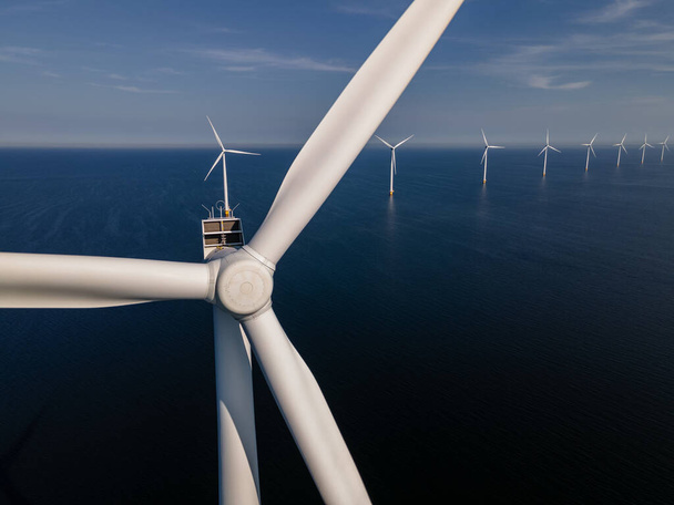 Ветряная турбина с высоты птичьего полета, вид с дрона на ветропарк Вестермердейк ветряная мельница ферма в озере Эйсселмер крупнейший в Нидерландах, устойчивое развитие, возобновляемые источники энергии - Фото, изображение