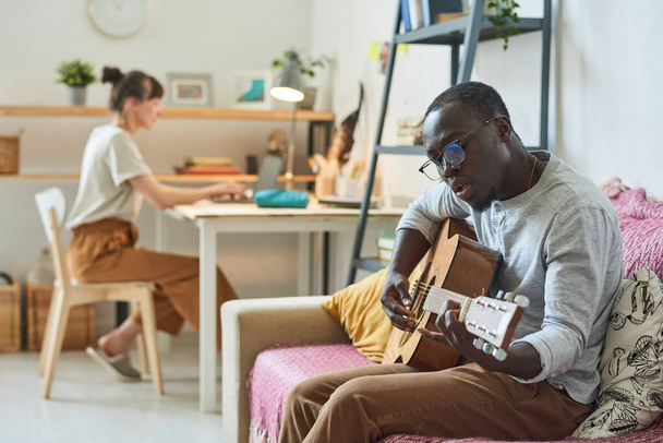 Hombre tocando la guitarra en la habitación - Foto, imagen