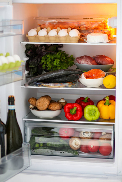 Full fridge of healthy food. Proper nutrition. The keto diet. Refrigerator with healthy food. Products in the refrigerator. Meat with vegetables. The concept of proper nutrition. Fish, red fish in the refrigerator, salmon, Seabass. - 写真・画像