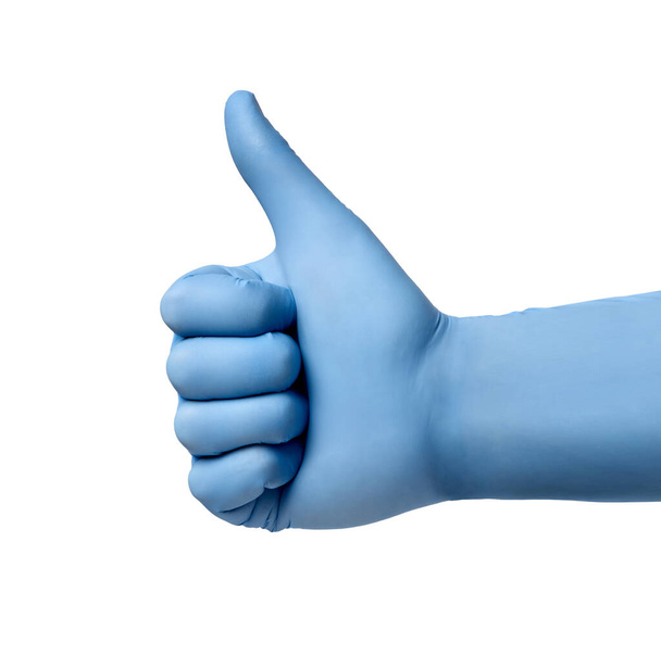 close-up van een hand met duim omhoog in blauwe latex beschermende handschoenen op witte achtergrond - Foto, afbeelding