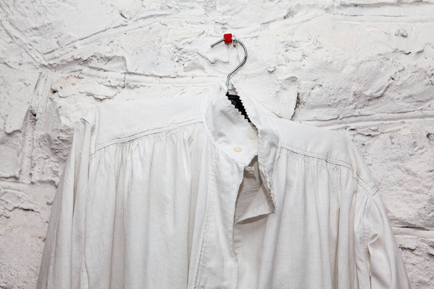 古いアンティークシャツ、古代のファッション布。ヴィンテージの白いシャツ。麻素材生地 - 写真・画像