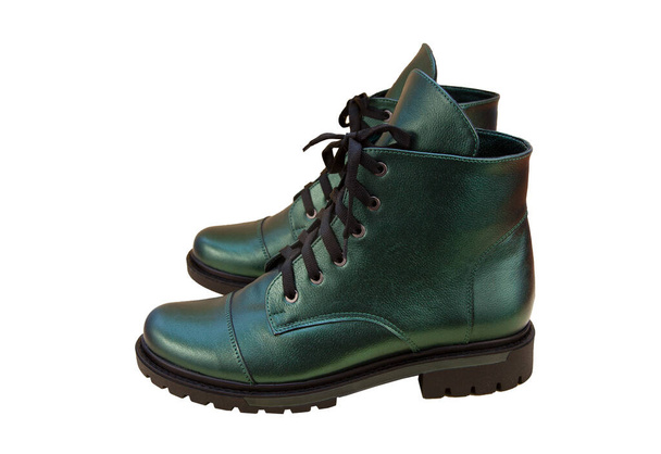 Green leather shoes isolated on white background. Winter and spring off-season boots. Stylish boot. Close-up. Laces, tractor sole. Casual style. Pearlescent fashionable color. - 写真・画像