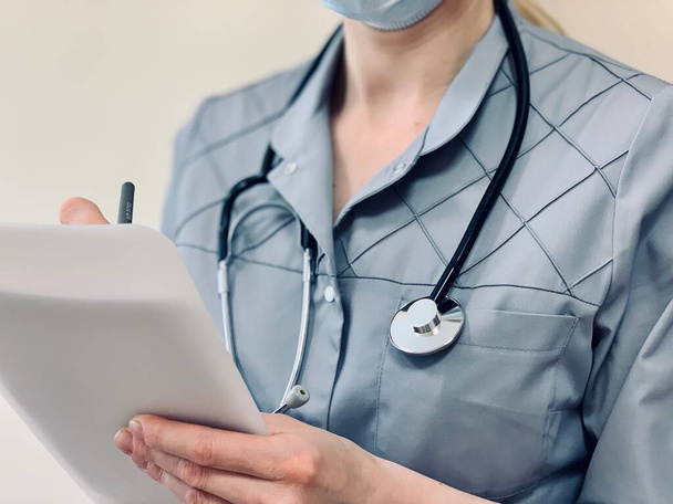 Ein Arzt oder eine Krankenschwester füllt medizinische Dokumente aus. - Foto, Bild