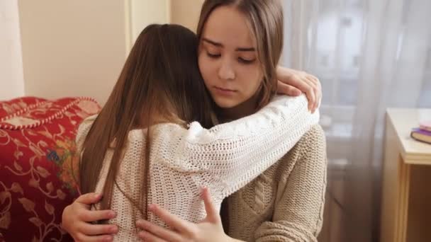 Ένα έφηβο κορίτσι αγκαλιάζει και παρηγορεί τον φίλο της που κλαίει στην κρεβατοκάμαρα. Υποστήριξη φίλων και κατάθλιψη εφήβων - Πλάνα, βίντεο