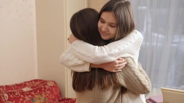 Χαρούμενη χαμογελαστή έφηβη που αγκαλιάζει και αγκαλιάζει τη φίλη της στο σπίτι. Ευτυχισμένοι έφηβοι μαζί - Πλάνα, βίντεο