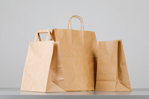 Bolsa de papel marrón con asas, bolsa de compras vacía con área para su logotipo o diseño, concepto de entrega de alimentos - Foto, imagen