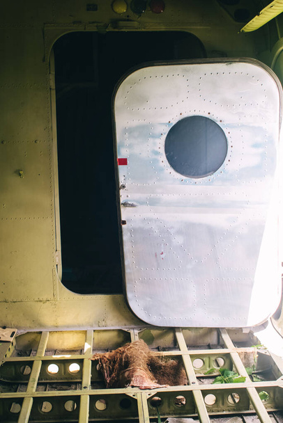 Un primer plano de un viejo avión de pasajeros destrozado que ha sido desmantelado y representa a los turistas. El fuselaje muestra rastros de óxido y papas fritas. Partes de la estructura metálica son visibles en las alas - Foto, Imagen