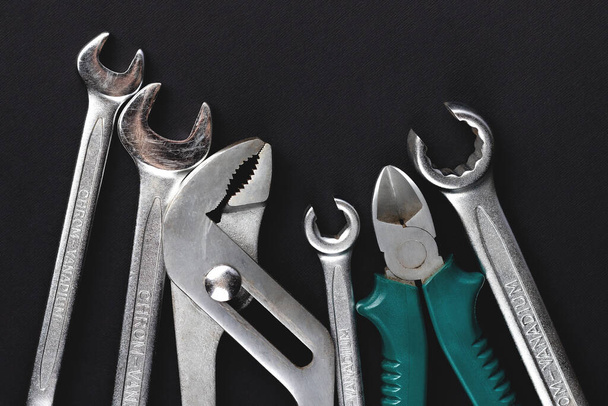 Work tools on black, dark gray background. Top view, flat lay - Photo, Image