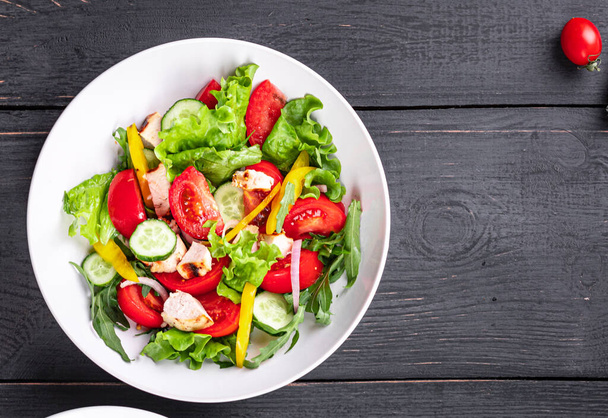 zöldség saláta és csirke hús zöldség friss paradicsom, uborka, bors bio étel az asztalon egészséges étel snack másolja tér élelmiszer háttér rusztikus. felülnézet - Fotó, kép