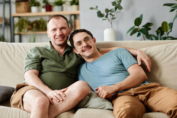 Happy gay couple sitting at home - Foto, imagen