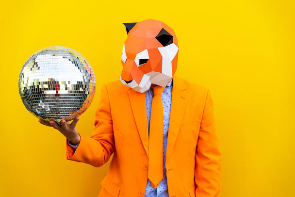 Cool man wearing 3d origami mask with stylish colored clothes - Creative concept for advertising, animal head mask doing funny things on colorful background - Photo, image