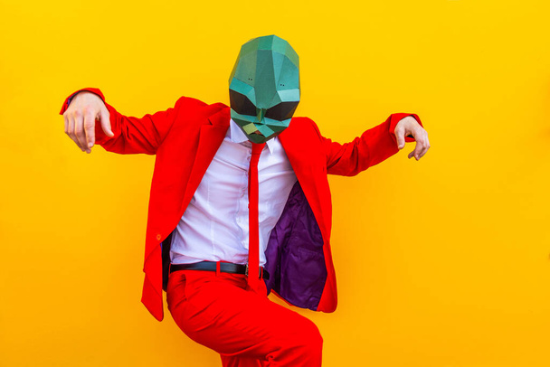 Cool man wearing 3d origami mask with stylish colored clothes - Creative concept for advertising, animal head mask doing funny things on colorful background - Zdjęcie, obraz