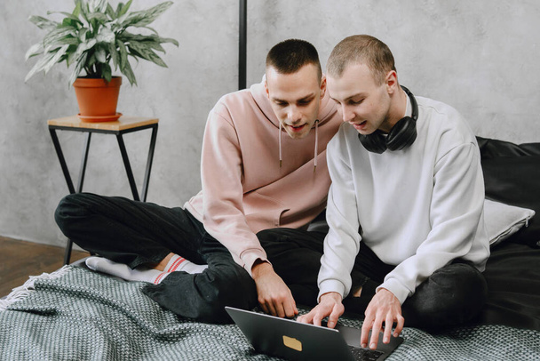 Gay couple consulting their travel plans together with a laptop - Foto, afbeelding