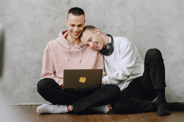 Gay couple consulting their travel plans together with a laptop - Foto, Bild