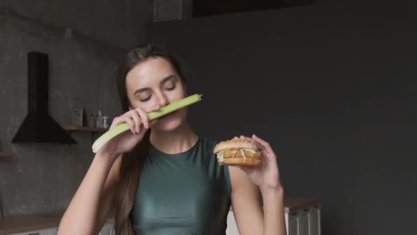Kavkazská žena jí burger, zatímco drží přírodní pórek v ruce s úsměvem po rozhodnutí - Záběry, video