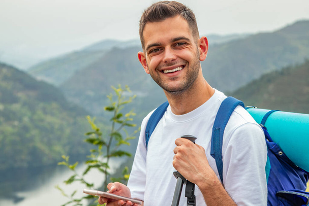 young man traveling with backpack and mobile phone - Foto, Bild
