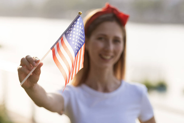 Patriotic holiday. Happy family, mother and daughter with American flag outdoors on sunset. USA celebrate independence day 4th of July. - 写真・画像