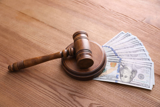 Judge's gavel and dollar bills on wooden table - Fotó, kép