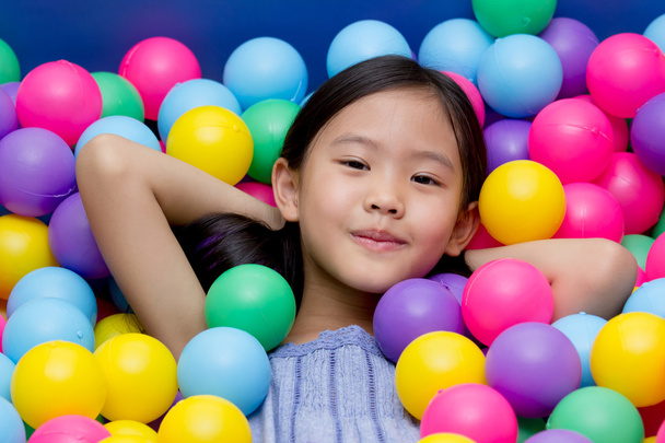 szczęśliwy Azji dziecko w przedszkolu z kolorowe kulki - Zdjęcie, obraz