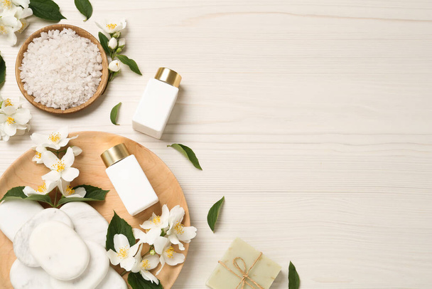 Flat lay composition with spa stones and beautiful jasmine flowers on white wooden table, space for text - Photo, Image