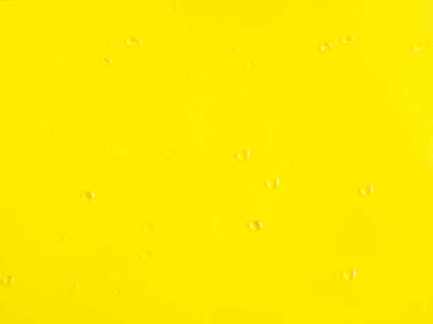 Fondo amarillo negrita con gotas de agua en la superficie - Foto, imagen
