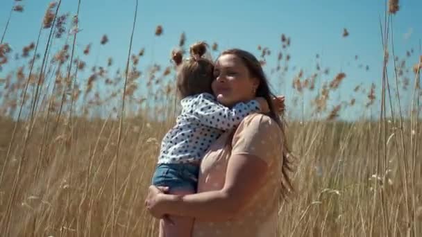 Glücklich lächelnde Frau mit einem kleinen Mädchen im Schilf in der Natur. Mutter haben spaß mit sie tochter - Filmmaterial, Video