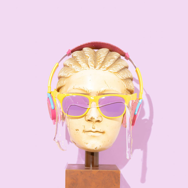 Pop art. Statue head with sunglasses. Trendy summer concept. Pop art. Colorful sunglasses covered with slime. Pink headphones. On pastel purple background. - Foto, Imagen