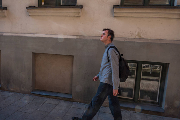 Malmo, Sweden A young man with a backpack walks on a street in the old town. - 写真・画像