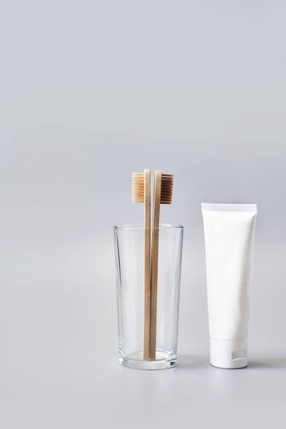 Ecology toothbrush on grey background. Brush in glass. Sustainable mouth product - Fotoğraf, Görsel