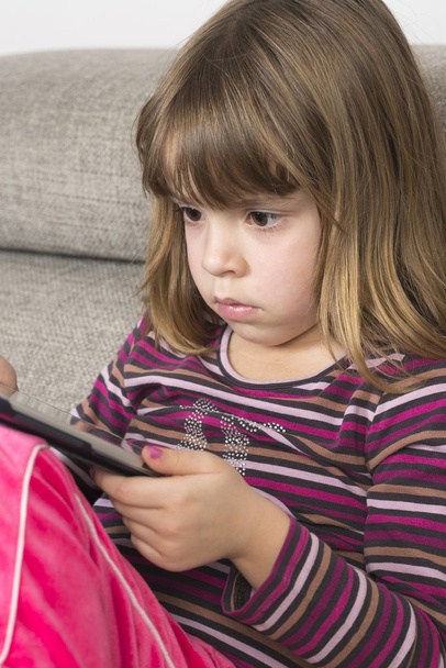 Little girl playing with a digital tablet - Фото, зображення