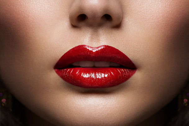 Red Lips Close up. Woman Beauty Face Make up. Glossy Shiny Lipstick Cosmetic. Model with Plump Lips Sexy Mouth - Φωτογραφία, εικόνα