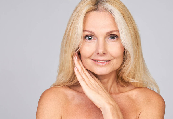 Attractive mature woman looking at camera isolated on white. Mature gorgeous lady close up portrait. Healthy beauty face skin care, middle age skin care cosmetics, cosmetology concept. - Foto, Imagen