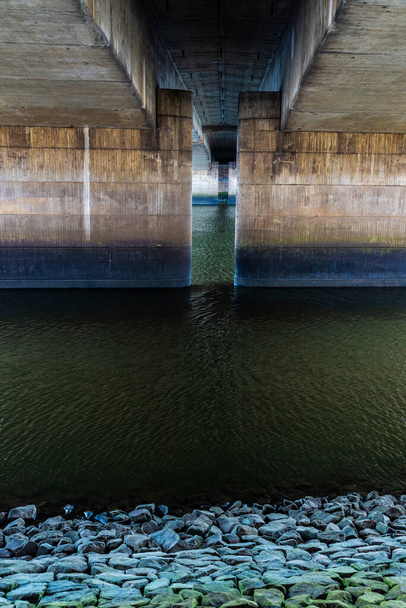 Άποψη των τσιμεντένιων στηλών κάτω από μια γέφυρα ως αφηρημένο φόντο στον ποταμό Weser Promenade (Schlachte) στη Βρέμη, Γερμανία - Φωτογραφία, εικόνα