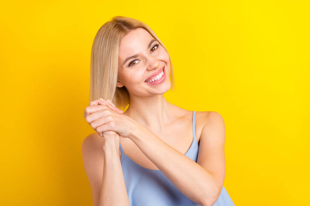 Photo of positive blond short hair lady hold hands wear blue top isolated on yellow color background - Valokuva, kuva