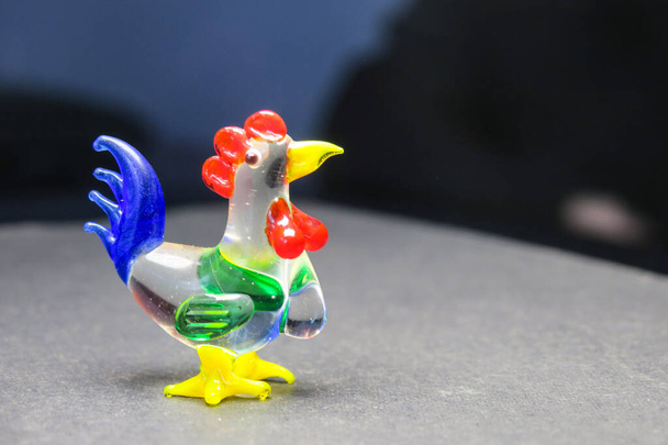 Little glass toy rooster on a black background - Photo, Image