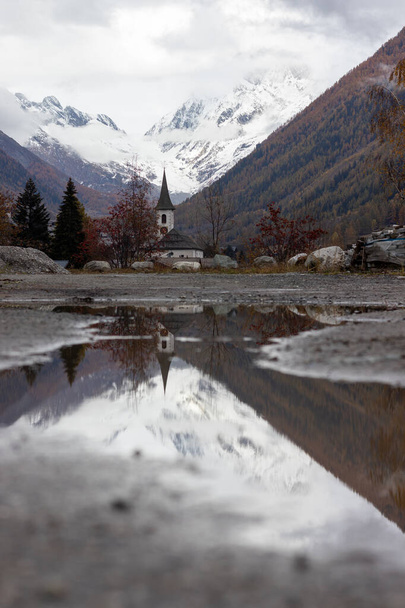 Moody Sveitsin kirkko Alppien alueella heijastuu pieni lätäkkö - Valokuva, kuva