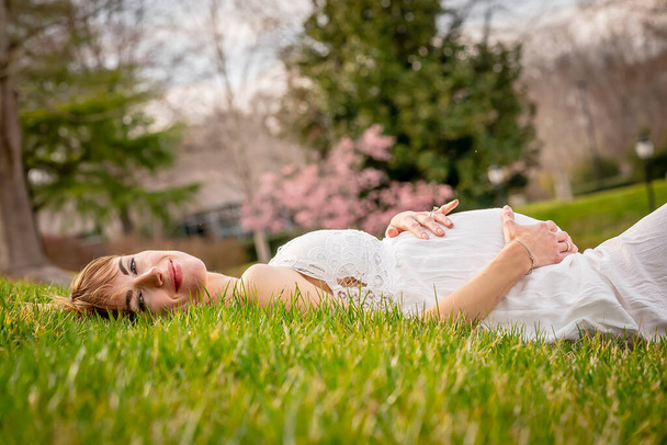 Egy gyönyörű várandós anya pózol a szabadban - Fotó, kép